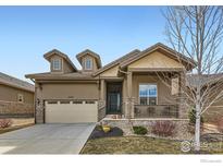 Inviting single-Gathering home featuring a covered front porch, a two-car garage, and manicured landscaping at 4420 White Rock Dr, Broomfield, CO 80023