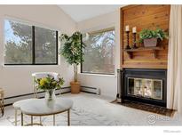 Cozy living room with a fireplace, and beautiful views from the bright windows at 6877 Countryside Ln # 277, Niwot, CO 80503