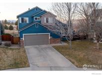 Two-story blue home with a two-car garage and well-maintained front yard at 92 Kolar Ct, Erie, CO 80516