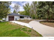 Charming single-story home with attached garage, long driveway and mature landscaping at 10587 N 95Th St, Longmont, CO 80501