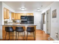 Bright kitchen features granite countertops, wooden cabinets, and a modern black appliance set at 1405 Broadway # 101, Boulder, CO 80302