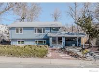 Charming two-story home with a blue exterior, covered car port, and lovely landscaping at 1615 Kalmia Ave, Boulder, CO 80304