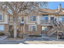 Inviting townhouse showcasing brick and siding, a wooden staircase, and a well-maintained landscape at 185 S Sable Blvd # 29, Aurora, CO 80012