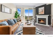 Inviting living room with a cozy fireplace, stylish furnishings, and bright natural light from sliding glass doors at 2192 Eagle Ave, Superior, CO 80027