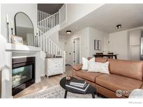 Cozy living room with fireplace, stylish decor, and staircase access at 2426 W 82Nd Pl # D, Westminster, CO 80031