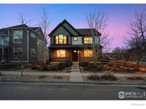 Charming two-story home featuring a welcoming front porch and well-maintained landscaping at dusk at 2811 Twin Lakes Cir, Lafayette, CO 80026