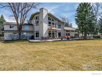 Spacious backyard featuring a large patio with outdoor seating and mature trees, perfect for entertaining at 303 Sky Lark Way, Boulder, CO 80303