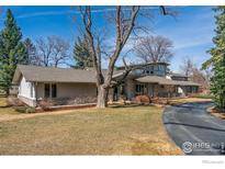 Inviting single story home featuring a well manicured lawn, mature landscaping, and a winding driveway at 303 Sky Lark Way, Boulder, CO 80303