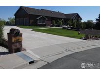 Beautiful brick home with a long driveway and well-manicured front yard at 3310 Routt St, Wheat Ridge, CO 80033