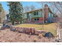 Charming two-story home featuring a well-maintained lawn, stone wall, and mature landscaping for inviting curb appeal at 4361 Butler Cir, Boulder, CO 80305