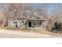 Charming gray home with a covered front porch and mature trees in the yard at 635 Alpine Ave, Boulder, CO 80304