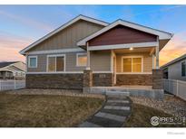 Charming single-story home featuring stone accents and a welcoming front porch, complemented by a well-maintained lawn at 636 Morrison Dr, Frederick, CO 80530