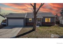 Charming single-story home boasts brick accents, a well-manicured lawn, and a two-car garage at 12510 Newton St, Broomfield, CO 80020