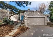 Charming two-story home with a stone pathway leading to a blue front door and attached two-car garage at 1425 Blue Sage Ct, Boulder, CO 80305