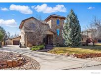 Attractive stone home featuring mature landscaping, stone accents, and a paved driveway at 1652 Poplar Ave, Boulder, CO 80304