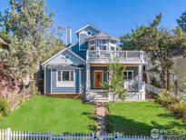 Charming blue two-story home with a turret and white picket fence offers curb appeal at 1727 Mapleton Ave, Boulder, CO 80304