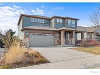 Two-story home featuring a two-car garage and stone-accented porch columns at 1860 Pioneer Cir, Lafayette, CO 80026