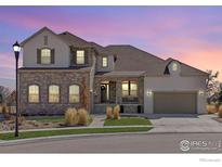 Charming two-story home showcasing a stone facade, manicured lawn, and attached two car garage at 2232 Sedgwick Ct, Longmont, CO 80503