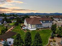 Expansive backyard with a patio, lush lawn, mountain views, and a built-in putting green at 2232 Sedgwick Ct, Longmont, CO 80503