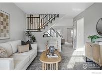 Inviting living room featuring a staircase and neutral tones throughout the well-lit space at 229 S Cleveland Ave, Louisville, CO 80027