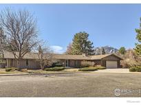 Charming single-story brick home with mountain views, mature trees, and a well-maintained front yard at 325 Fox Ct, Boulder, CO 80303