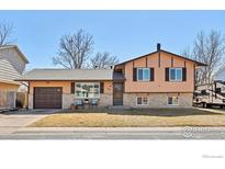 Charming two-story home with a well-maintained lawn and a mix of brick and siding exterior at 326 Berwick Ave, Firestone, CO 80520