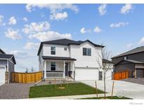 Charming two-story home with a landscaped yard, covered porch, and a two-car garage in a suburban neighborhood at 4115 Marble Dr, Mead, CO 80504