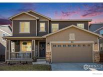 Charming two-story home with a welcoming front porch and a well-maintained lawn at 841 Gold Hill Dr, Erie, CO 80516