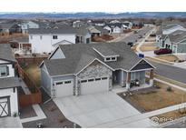 Beautiful single Gathering home featuring a three-car garage, stone accents, and mountain views at 213 Rocking Chair Dr, Berthoud, CO 80513