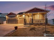 Inviting home featuring a covered porch with stone accents and a well-maintained front yard at 2161 Cadman St, Berthoud, CO 80513