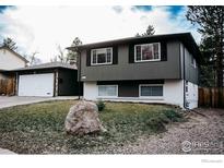 Two story home showcasing a quaint exterior with green tones and white brick at 6833 S Buffalo St, Littleton, CO 80120