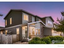 Charming two-story home featuring stone accents, covered porch, and landscaped front yard at 6894 E 133Rd Pl, Thornton, CO 80602