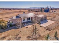 Stunning modern home with metal roof, beautiful stone landscaping, and attached three-car garage on a large lot at 11251 Lookout Dr, Longmont, CO 80504