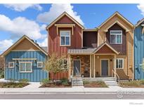 Attractive townhome exterior with colorful facade, stone accents, and charming landscaping at 1317 Country Ct # B, Longmont, CO 80501