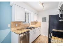 Bright kitchen with modern stainless-steel appliances, granite counters, white cabinets, and tile backsplash at 14760 E Kentucky Dr # 312, Aurora, CO 80012