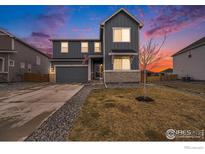 Two-story home with neutral siding, an attached garage, and a manicured lawn at 14762 Charbray St, Mead, CO 80542