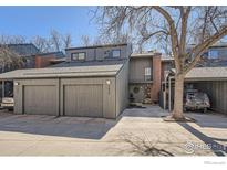 Contemporary townhouse with gray siding, brick accents, two-car garage and a tree in the front yard at 1513 48Th St, Boulder, CO 80303