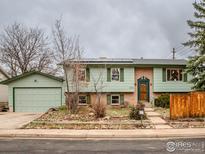 Split level home featuring light green siding, updated windows, and solar panels at 1805 Del Rosa Ct, Boulder, CO 80304