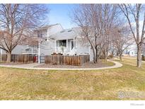 Charming townhome with gray siding, complemented by a well-maintained lawn and mature trees at 300 Owl Dr, Louisville, CO 80027