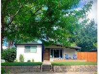 Charming single-story home featuring a well-maintained lawn and covered porch with blue rocking chairs at 4970 Hooker St, Denver, CO 80221