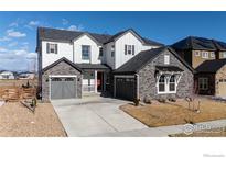 Beautiful two-story home with stone accents, a well-manicured lawn, and a spacious driveway at 751 Green Mountain Dr, Erie, CO 80516