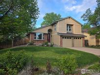 Charming two-story home with a well-manicured lawn and a two-car garage at 10895 W Half Moon Pass, Littleton, CO 80127