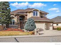 Charming two-story stucco home featuring stone accents, mature landscaping, and a three-car garage at 1145 Wyndemere Cir, Longmont, CO 80504