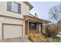 Charming home featuring a front-facing two car garage and quaint brick-clad porch at 1735 S Kline Way, Lakewood, CO 80232