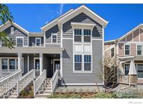 Charming townhome featuring gray siding, white trim, and a welcoming front porch with a well-manicured landscape at 186 Washington St, Erie, CO 80516