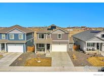 Two-story home featuring solar panels, a two-car garage, and a well-maintained, xeriscaped front yard at 2425 Mountain Sky Dr, Fort Lupton, CO 80621