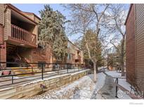 Exterior view of the community showing multiple units with brick and wood siding and snowy walkways at 316 Wright St # 203, Lakewood, CO 80228