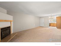 Bright living room featuring a fireplace, neutral walls, and access to the kitchen at 316 Wright St # 203, Lakewood, CO 80228