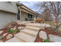 Inviting front entrance with concrete steps, lush landscaping, and covered porch with seating area at 4705 Chatham St, Boulder, CO 80301