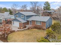Charming two-story home with a well-manicured lawn, brick accents, and an attached two-car garage at 7599 Concord Dr, Boulder, CO 80301